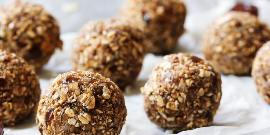 Momday pregnancy nutrition blog post of a recipe and benefits of lactation protein balls. Image of the oats and other ingredients rolled into balls on a white cloth.